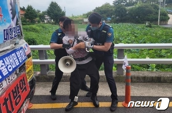 16일 문재인 전 대통령 사저가 있는 양산 하북면 평산마을 앞 도로에서 흉기를 휘두른 60대 남성이 경찰에 체포되고 있다. (독자 제공)