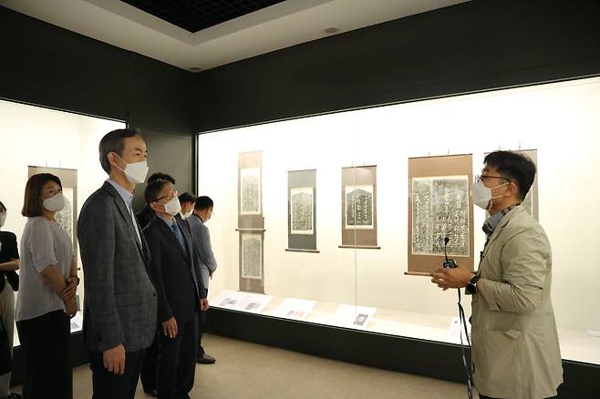이호영 창원대학교 총장 등이 지난 11일 창원대 박물관에서 개막한 창원대학교 박물관-해군사관학교 박물관 연합특별전시회 '잊혀진 이야기, 역사가 되다' 전시 작품에 대한 설명을 듣고 있다. /창원대