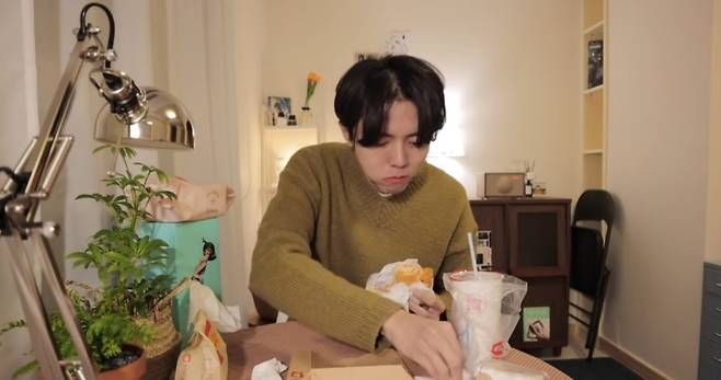 Model Joo Woo-jae eats a burger in a meokbang for his YouTube channel (YouTube)