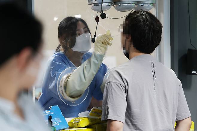 18일 오전 서울 용산구보건소 선별진료소에서 의료진이 검사를 하고 있다. 연합뉴스