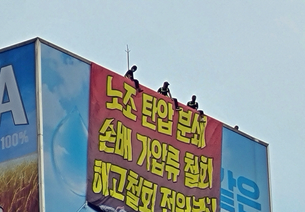 화물연대 조합원들이 18일 오후 서울 강남구 청담동 하이트진로 본사 옥상에서 고공 농성을 벌이고 있다. [이상현 기자]