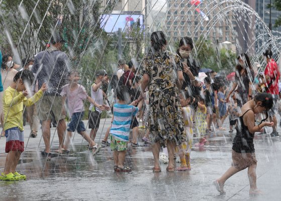 지난 14일 광화문광장에서 어린이들이 물놀이하고 있다. 온실가스를 줄이지 않는 시나리오에 따르면 21세기 말까지 동아시아에서는 한여름이 지금보다 15% 이상 길어질 것으로 예측됐다. 연합뉴스