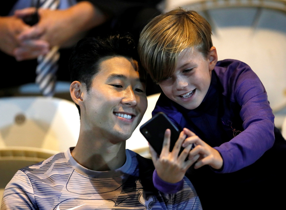 Tottenham Hotspur's Son Heung-min poses for a photo with a young fan at JobServe Community Stadium, Colchester in Britain on Sept. 24, 2019. [REUTERS/YONHAP]