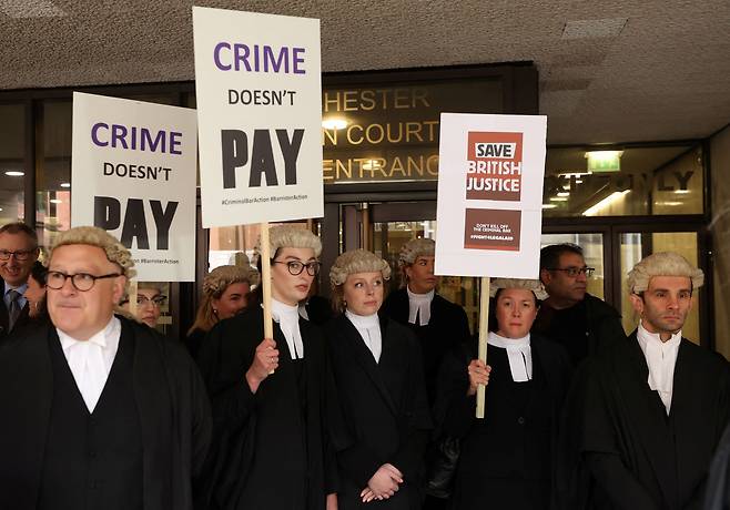 지난 6월 27일(현지 시각) 영국 맨체스터 형사법원 밖에서 국선변호인들이 수당 25% 인상을 요구하며 파업 시위를 벌이고 있다.