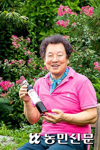 김영도 대표가 노곡산방에서 와인을 들고 활짝 웃고 있다.