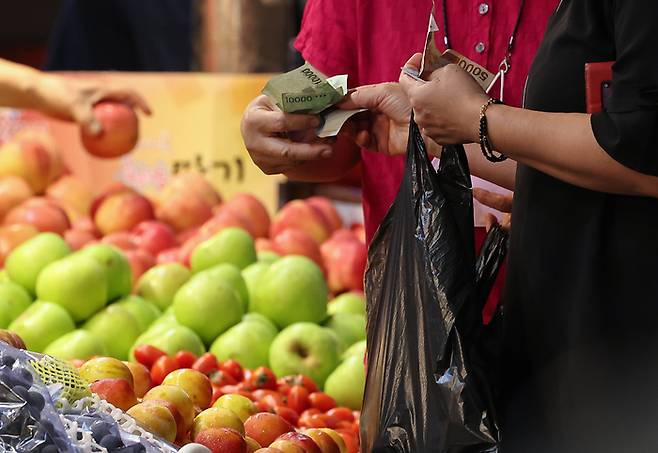 서울 동대문구 청량리청과시장에서 한 시민이 과일을 구매하고 있다. 연합뉴스.
