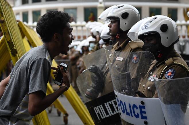 지난 7월 22일 스리랑카 콜롬보에서 라닐 위크레메싱게 신임 대통령에 반대하는 시위에 나선 한 시민이 도로를 통제하고 있는 경찰에게 소리 지르고 있다. 새 대통령이 선출됐음에도 스리랑카의 정치 혼란이 이어지고 있다.