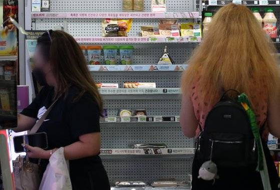 서울시내 한 편의점에서 시민들이 삼각김밥과 샌드위치 등을 고르고 있다. 뉴스1.