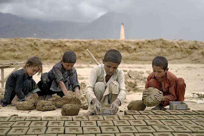 지난 7월 23일 아이들이 벽돌 공장에서 벽돌을 만들고 있다. 카불/AP 연합뉴스