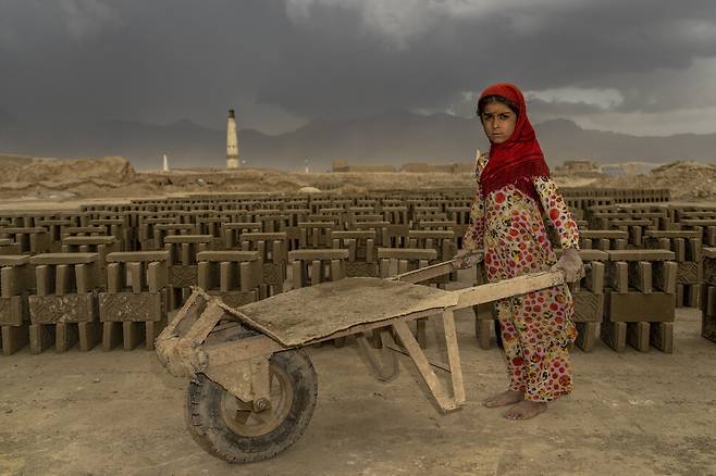 지난 9월 12일 9살 소녀가 손수레를 이용해 물건을 나르려 하고 있다. 카불/AP 연합뉴스