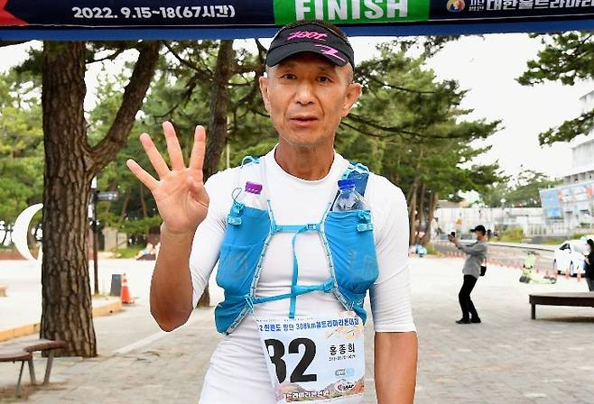 홍종희씨가 지난 17일 강원 강릉에서 끝난 2022 한반도 횡단 울트라마라톤대회에서 우승한 뒤 ‘네 번째 우승’이라는 의미로 손가락 네 개를 펴보이고 있다. 홍종희씨 제공