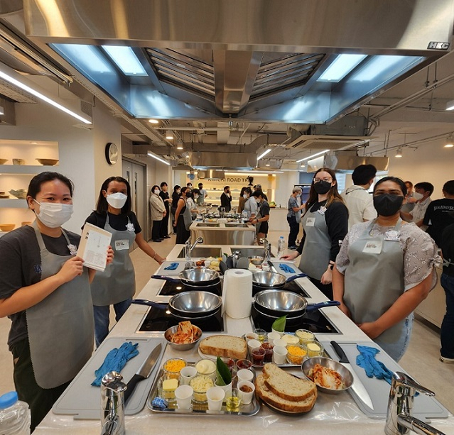 Participants pose for a photo before making kimchi grilled cheese sandwiches at a one-day cooking class held Tuesday at Hansik Space E:eum in Seoul's Bukchon. (Choi Jae-hee/The Korea Herald)