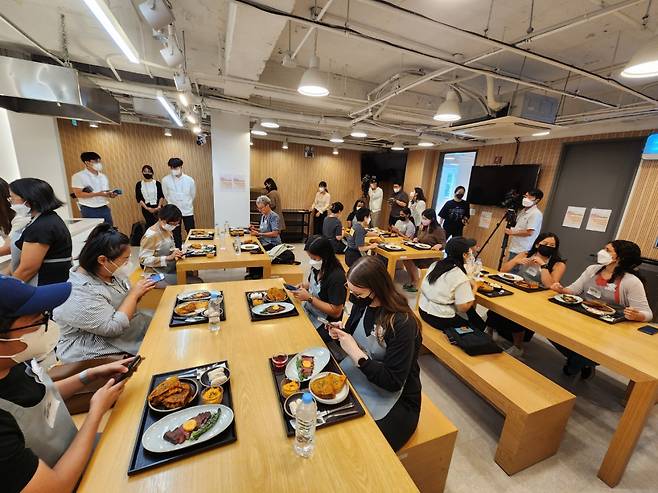 Participants get to taste the kimchi grilled cheese sandwich they made along with chef-prepared strip steak. (Choi Jae-hee/The Korea Herald)