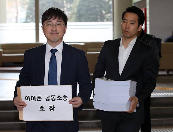 법무법인 한누리 관계자들이 2018년 애플 코리아를 상대로 하는 손해배상청구 소장을 서울중앙지방법원에 내고 있다. 이날 제출한 원고 명단은 6만여 명이지만 복잡한 절차 때문에 현재 9000여 명으로 줄었다. ‘클래스 액션’ 제도가 있는 나라에서는 대표 피해자를 뽑아 소송을 진행한다. (출처:연합뉴스)