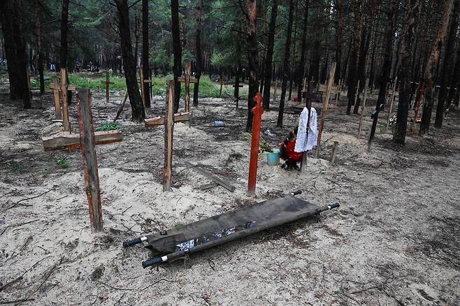 지난 17일(현지 시각) 우크라이나 이지움 인근 숲의 매장지에 십자가가 설치돼있다. 우크라이나 국방부는 최근 러시아로부터 수복에 성공한 이지움 지역에서 시신 450구 이상이 묻힌 집단매장지가 발견됐다고 밝혔다. /AFP·연합뉴스