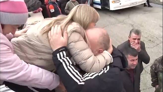 22일(현지 시간) 러시아 동부 사하공화국 야쿠츠크에서 한 남성이 입영소로 향하는 버스에 오르기 전 가족으로 보이는 여성과 부둥켜안고 작별 인사를 하고 있다.  텔레그램 영상 캡처