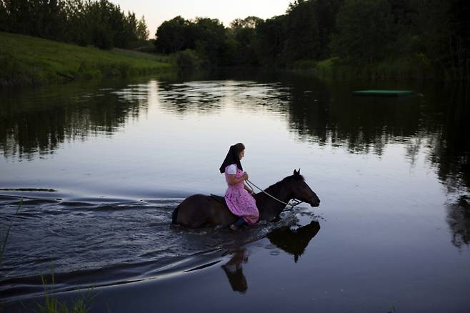 해질녁, 하다사 멘델이 말을 타고 호수를 건너고 있다. 2016년 베이커 자치구. ⓒTim Smith