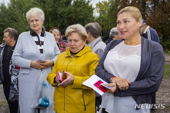 [AP/뉴시스] 23일 러시아군이 95% 점령하고 러시아계 주민들이 많이 살고있는 우크라이나 루한스크주의 주도 루한스크시 인근 마을에서 주민들이 이동 투표소 앞에 서 있다
