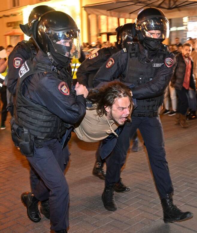 러시아 경찰들이 21일(현지시간) 블라디미르 푸틴 대통령이 발동한 동원령에 반대하는 시위 참가자를 체포하고 있다.   모스크바 AFP=연합뉴스