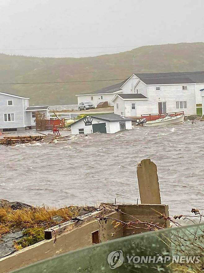 홍수에 통째로 떠내려가는 주택 (AFP=연합뉴스) 24일(현지시간) 허리케인 피오나가 불어닥친 캐나다 뉴펀들랜드주에서 주택이 통째로 물에 떠내려가고 있다. 2022.9.24.