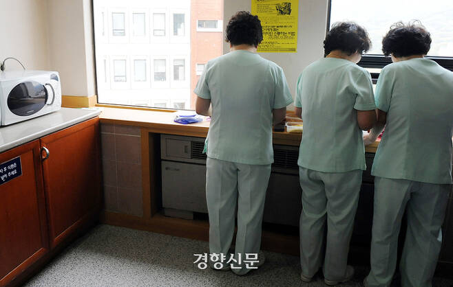 2010년 서울대병원 본관 병동의 한 배선실  창가에서 간병노동자들이 선 채로 점심식사를 하고 있다. 서성일기자