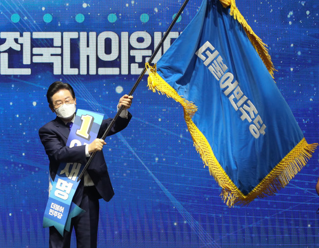 8월 28일 이재명 더불어민주당 의원이 서울 송파구 올림픽 체조경기장에서 열린 제5차 정기전국대의원대회에서 당대표로 선출된 뒤 당기를 흔들고 있다. [뉴시스]