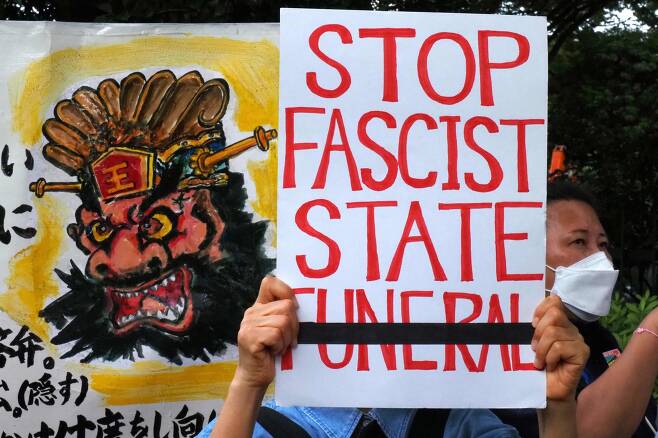 27일 일본 국회의사당 앞에서 한 시위자가 "파시스트 국장 반대" 피켓을 들고 시위를 벌이고 있다. AFP=연합뉴스