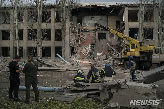 [미콜라이프=AP/뉴시스]구조대원들이 28일(현지시간) 우크라이나 미콜라이프에서 러시아군의 공격으로 학교가 심하게 파손된 후 한 여성이 숨진 채 발견된 현장에서 잔해를 치우고 있다. 2022.09.28.