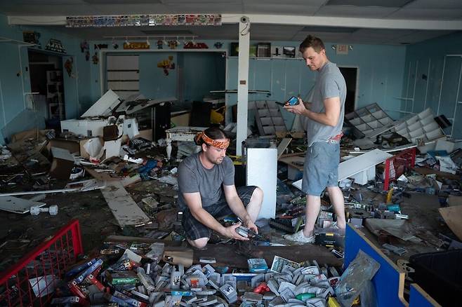 시민들이 플로리다주 보니타 스프링스 피해를 입은 가게에서 파괴된 물건들을 살펴보고 있다.AFP/연합뉴스
