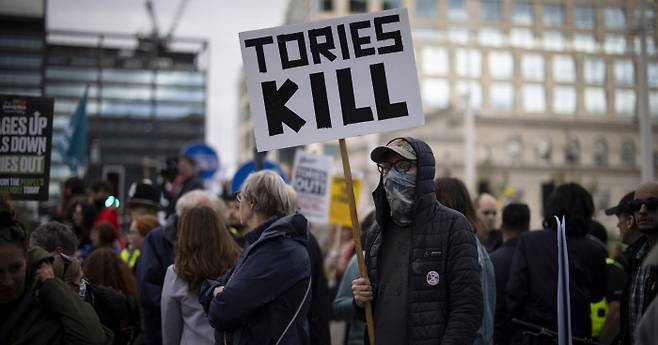 물가 폭등 항의하는 영국시민들 영국 보수당의 연례회의가 열리는 버밍엄의 국제컨벤션센터 앞에서 2일(현지시간) 한 시민이 정부의 감세안과 물가 폭등에 항의하는 손팻말을 들고 있다. 버밍엄 | EPA연합뉴스