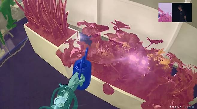 지난 1일(현지시간) 테슬라의 ‘AI데이2’에서 화분에 물을 주는 인공지능 로봇 ‘옵티머스’의 시점 영상이 스크린에 표출되고 있다. 테슬라 실시간 중계 화면 캡처