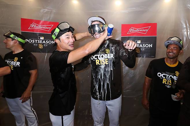 샌디에이고 김하성(왼쪽)이 3일 팀의 포스트시즌 진출이 확정된 뒤 선수단의 샴페인 세리머니에서 블레이크 스넬에게 맥주를 부으며 즐거워하고 있다. 샌디에이고 | AP연합뉴스