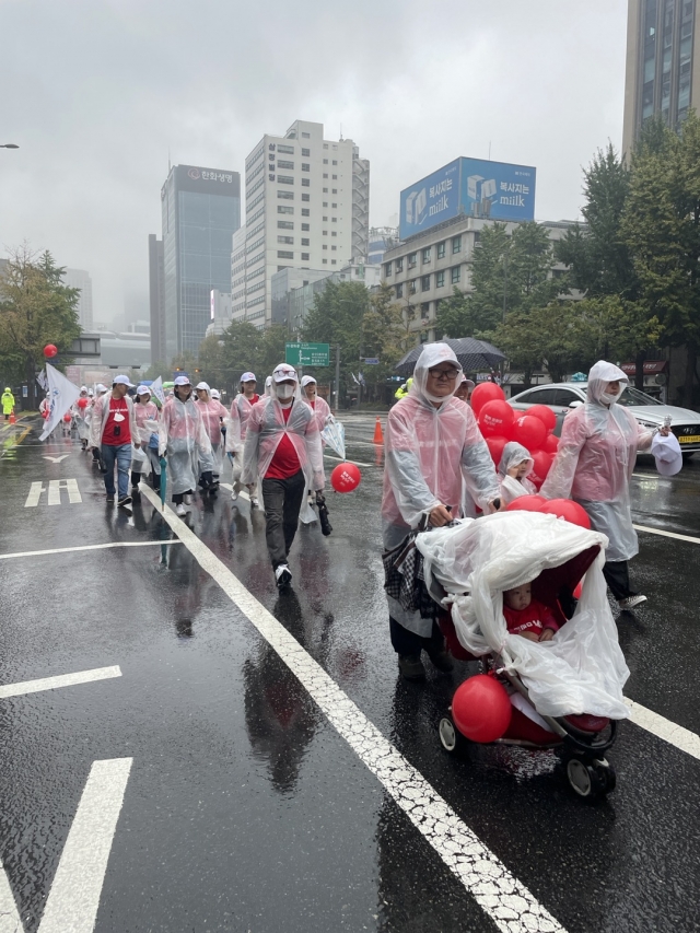 NCMN은 3일 걷기 행사인 ‘함께 걸어요 My5K’를 진행했다. 5000여명의 참가자들이 우비를 입은 채 서울광장에서 출발해 걷고 있다.