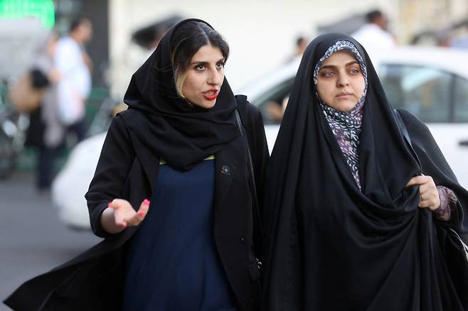 3일(현지시간) 이란의 수도 테헤란에서 히잡을 쓴 여성들이 도로를 걷고 있다. 이란에서는 지난달 13일 마흐사 아미니(22세)라는 여성이 히잡을 적법하게 착용하지 않았다는 이유로 풍속 단속 경찰에게 체포된 뒤 16일 의문사하자 고인을 추모하고 진상 규명을 요구하는 시위가 일어나고 있다. [연합]