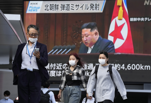 도쿄 시민들이 김정은 북한 국무위원장의 얼굴이 나오는 관련 뉴스를 방송하는 대형 스크린 앞을 걷고 있는 모습. EPA연합뉴스