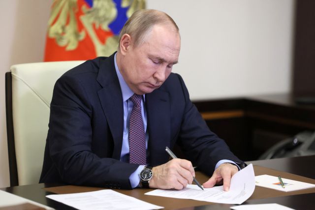 블라디미르 푸틴 러시아 대통령이 15일(현지시간) 수도 모스크바 외곽에서 회의 중 문서에 서명하고 있다. 로이터연합뉴스