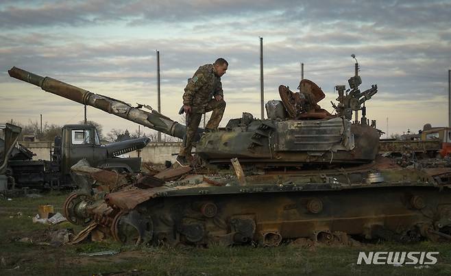 [헤르손=AP/뉴시스] 한 우크라이나 군인이 손상된 러시아 탱크를 조사하고 있다. 2022.11.15.