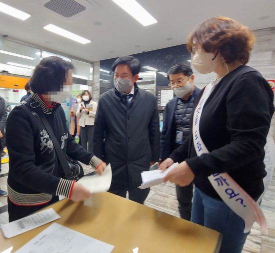 발급민원 서류 작성에 어려움을 겪고 있는 민원인을 돕고 있는 서강동주민센터 민원도우미와 박강수 마포구청장(왼쪽에서 두 번째)