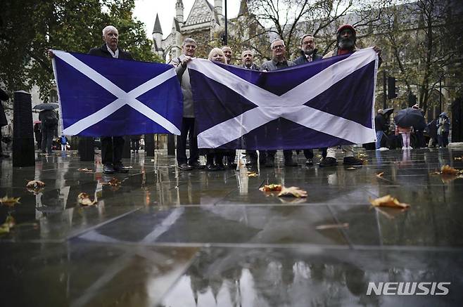 [런던=AP/뉴시스]스코틀랜드의 분리 독립을 지지하는 사람들이 11일 스코틀랜드의 독립 찬반투표 실시 여부를 결정하는 런던의 영국 대법원 앞에서 스코틀랜드 국기를 들고 결정을 기다리고 있다. 대법원은 이날 찬반투표를 다시 실시는 불가하다고 판결했다. 2022.11.23