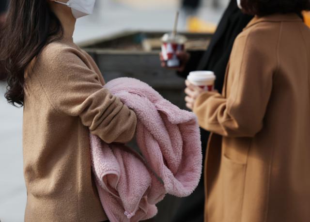 큰 추위 없는 늦가을 날씨가 이어진 21일 오후 겉옷을 손에 든 시민들이 광화문네거리를 지나고 있다. 연합뉴스