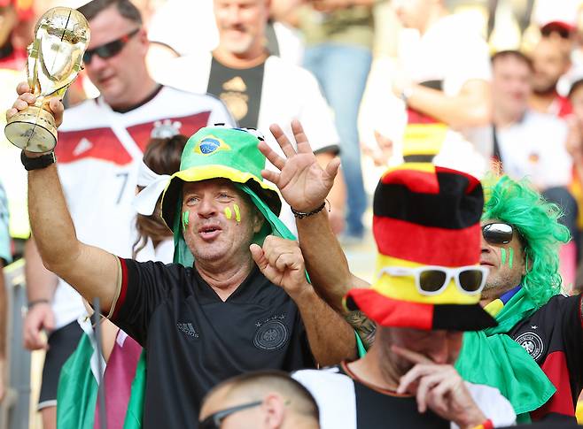 23일 오후(현지시간) 카타르 알라이얀의 할리파 인터내셔널 스타디움에서 열린 2022 카타르 월드컵 조별리그 E조 독일과 일본의 경기. 한 브라질 팬이 독일 축구팬들 사이에서 트로피 모형을 들고 응원을 하고 있다. [연합]