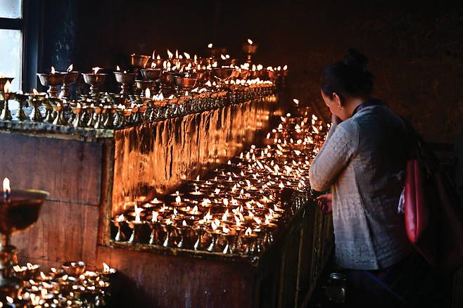 로기어곰파를 방문한 주민들이 조그만 그릇에 야크버터불을 피워 놓고 기원을 한다.