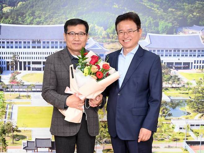 이철우 경북도지사가 25일 경북도청을 찾은 ‘봉화의 기적’ 주인공인 광부 박정하 작업반장에게 환영 꽃다발을 주고 있다. (경북도 제공) 2022.11.25