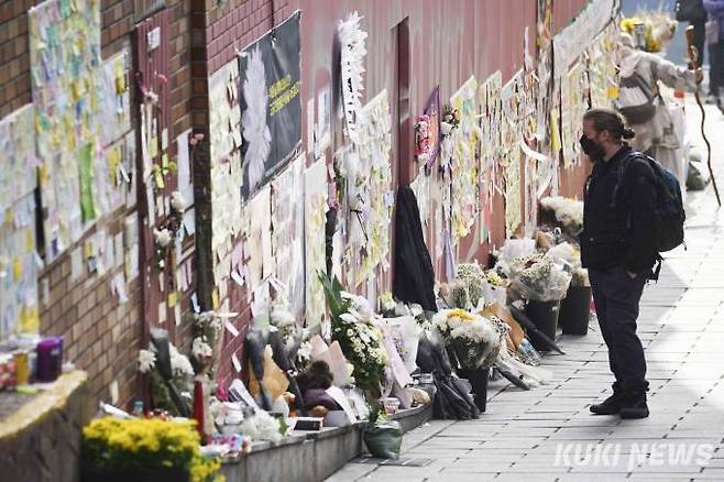 지난 21일 오전 서울 용산구 이태원 참사 현장에 마련된 추모공간에서 한 시민이 추모 메시지를 살펴보고 있다.   사진=임형택 기자