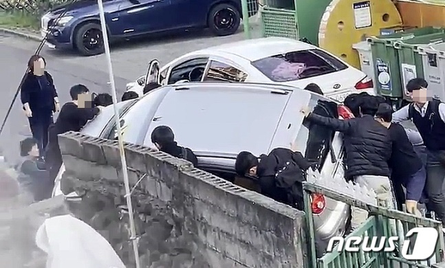 24일 오후 4시26분쯤 제주 서귀포시 동홍동의 한 골목길에서 시민들이 무면허 음주운전 차량에 깔린 A씨(70·여)를 구조하고 있다. /사진=뉴스1(독자 제공