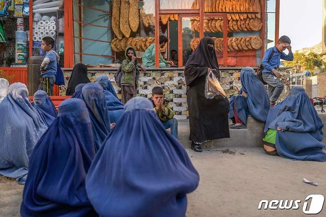 아프가니스탄 카불에서 부르카를 입은 여성들이 빵 기부를 받기 위해 빵집 앞에서 기다리고 있다. ⓒ AFP=뉴스1 ⓒ News1 노선웅 기자
