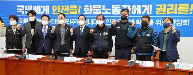 더불어민주당 박홍근 원내대표와 참석자들이 지난 25일 국회에서 열린 화물연대본부 안전운임제 확대를 위한 간담회에서 기념촬영을 하며 구호를 외치고 있다.