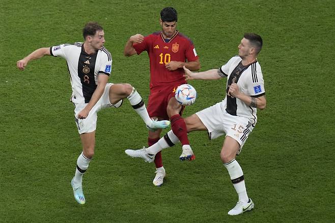 Spain's Marcos Asensio, centre, challenges for the ball with Germany's Leon Gorentzka, left, and Germany's Niklas Suele during the World Cup group E soccer match between Spain and Germany, at the Al Bayt Stadium in Al Khor, Qatar, Sunday, Nov. 27, 2022. (AP Photo/Ricardo Mazalan)
<저작권자(c) 연합뉴스, 무단 전재-재배포 금지>
