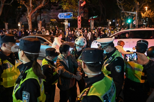 중국 경찰이 27일 상하이 우루무치 거리에서 신장 우루무치 화재 참사 추모 및 제로 코로나 반대 시위에 참가한 시민들을 연행하고 있다. AFP연합뉴스