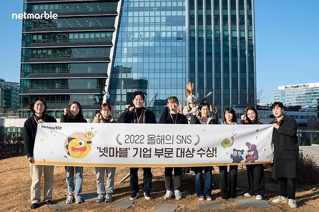 넷마블 임현섭 뉴미디어 팀장(왼쪽에서 네 번째)과 넷마블 뉴미디어 팀원들이 서울시 구로구에 위치한 넷마블 사옥 지타워에서 '2022 올해의 SNS' 대상 수상을 기념해 사진촬영을 하고 있다.